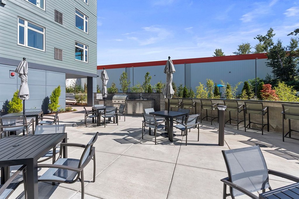 A patio with tables and chairs is surrounded by a red wall