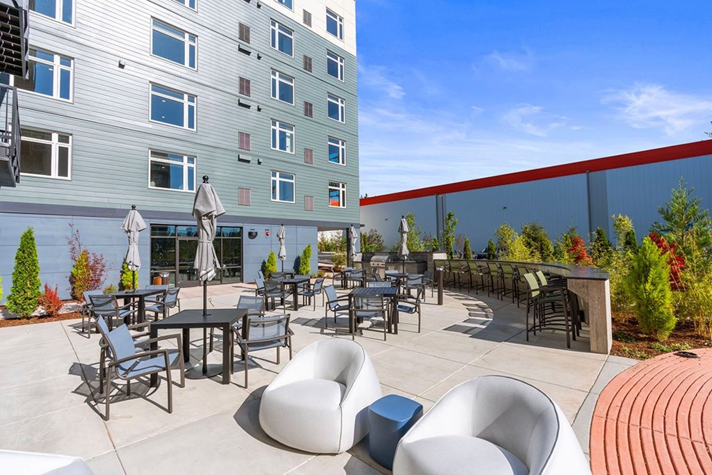 A patio with chairs and tables in front of a building