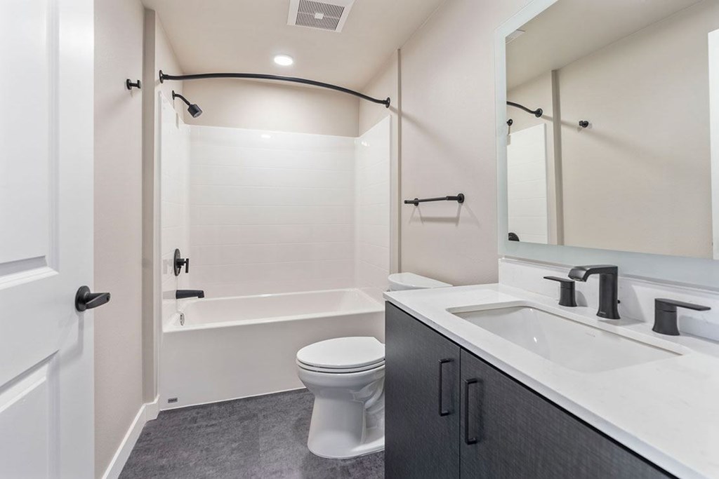 A white toilet sits in a bathroom next to a sink.