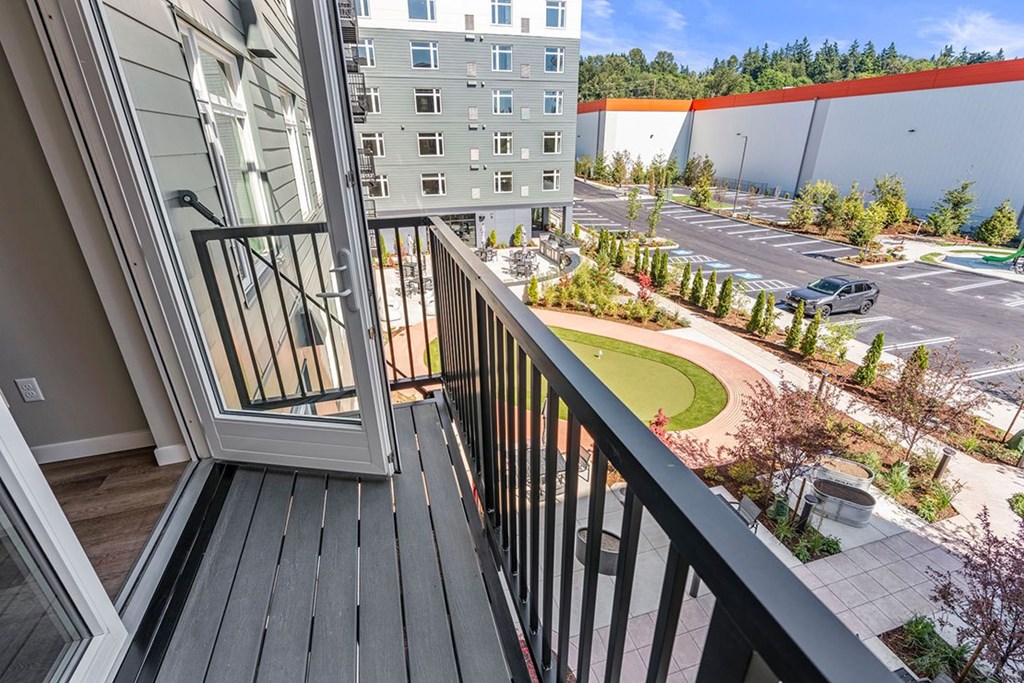 A balcony with a view of a parking lot and buildings