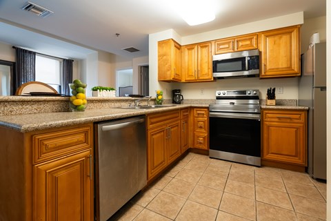 A kitchen with wooden cabinets and a stainless steel oven.