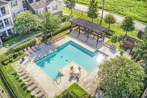 A swimming pool with a deck and a pavilion.