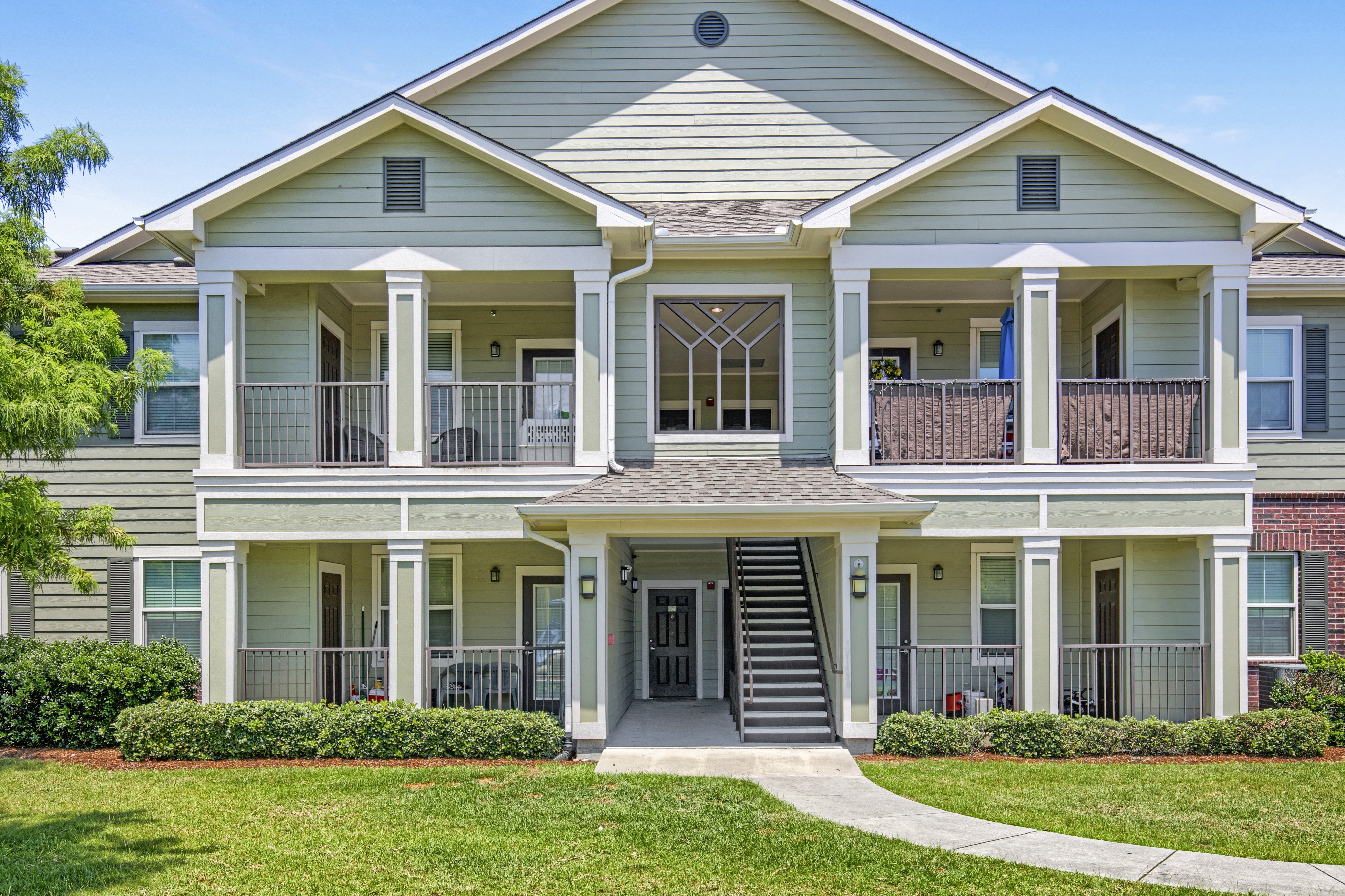 A two-story house with a front porch and a balcony on the second floor.