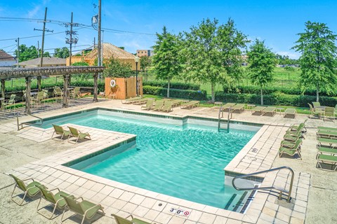 A large outdoor swimming pool surrounded by sun loungers.