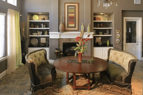 A living room with a fireplace and a painting on the wall.
