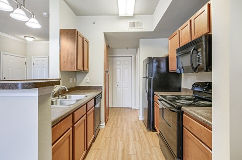 A kitchen with wooden cabinets and black appliances.