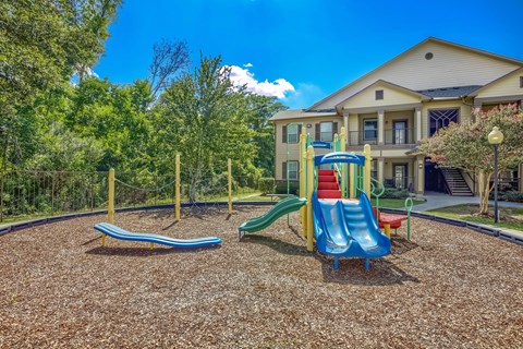 A playground with a blue slide and a red slide.