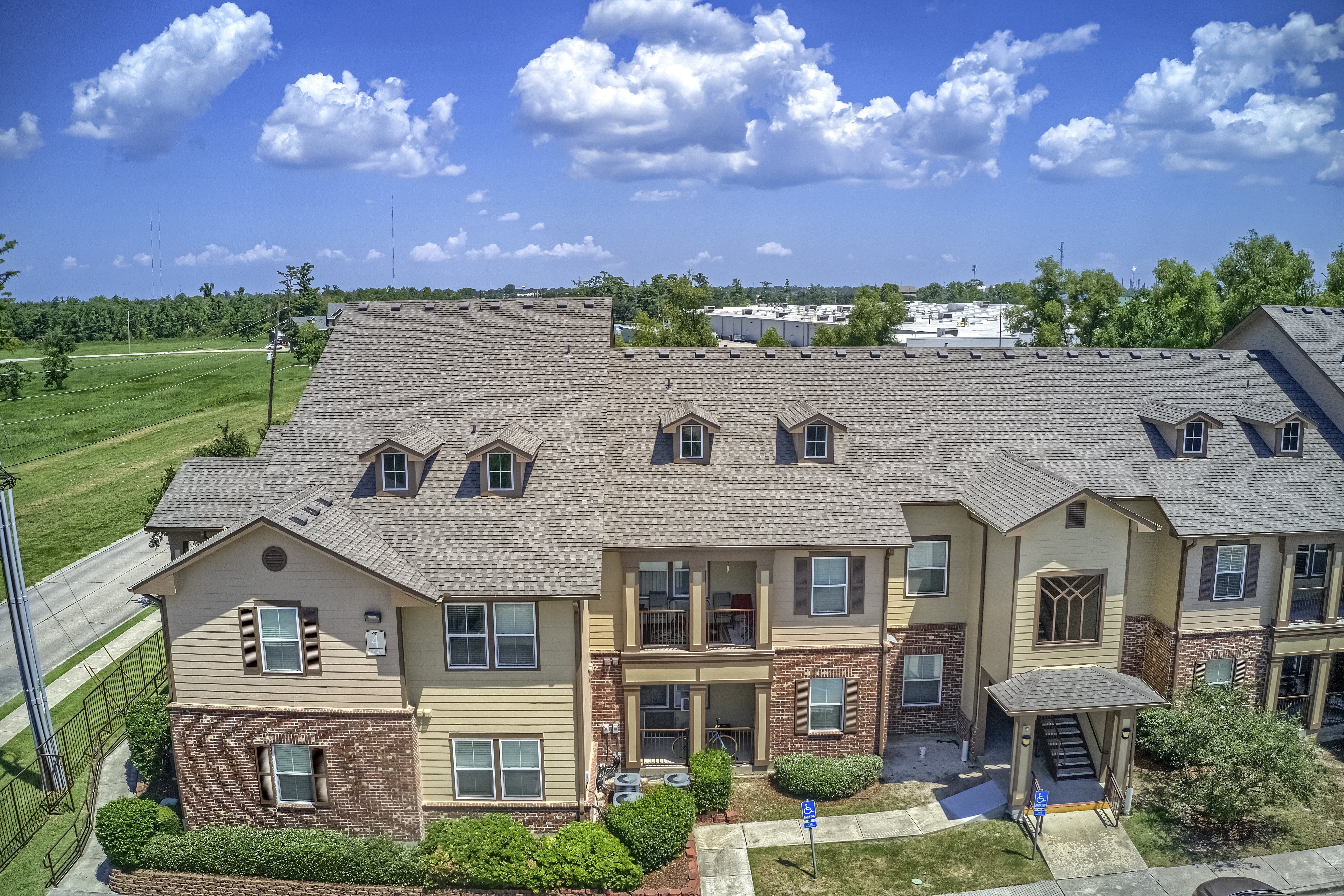 A large apartment complex with a green lawn in front.