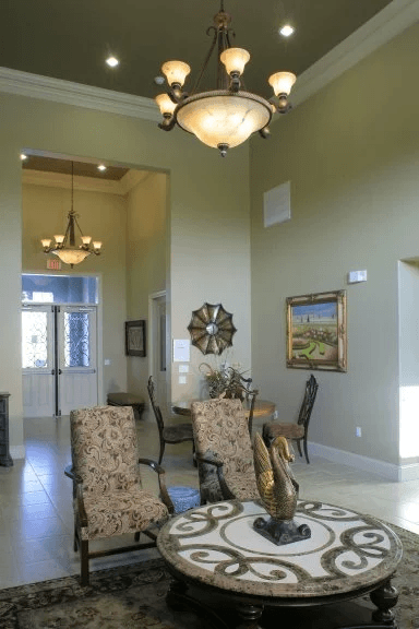 A living room with a patterned rug and a chandelier.
