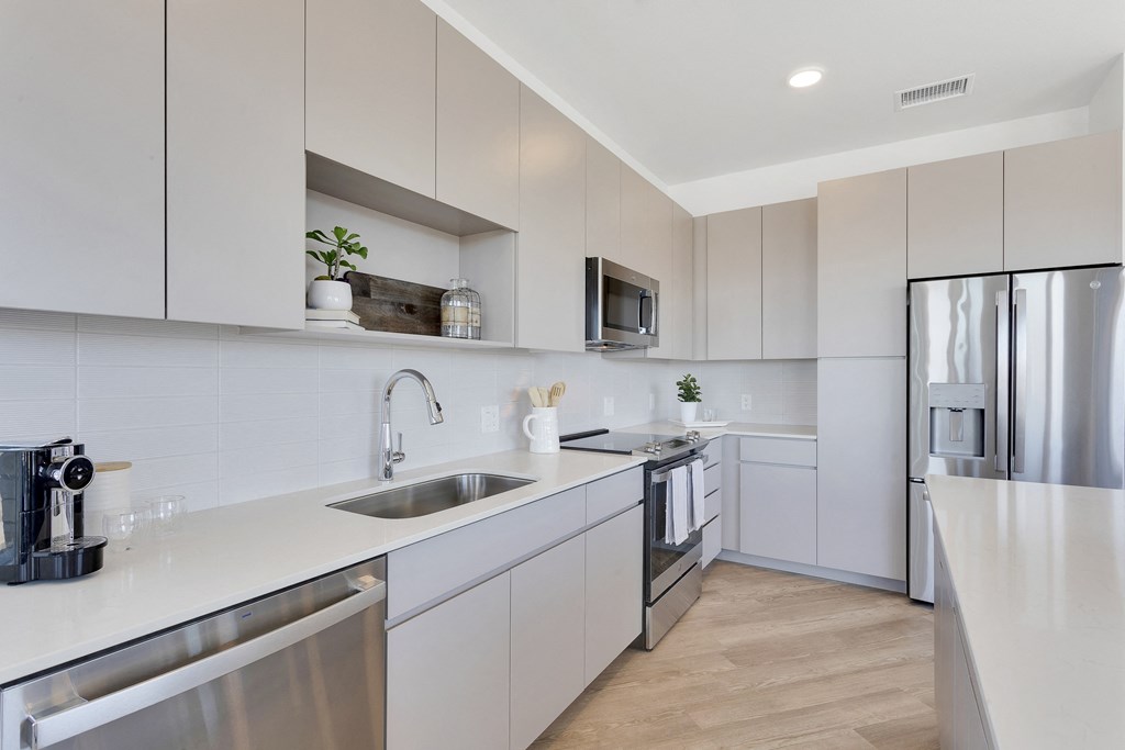 a kitchen with white cabinets and stainless steel appliances