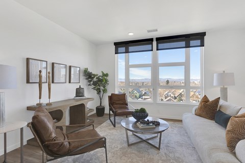 a living room with a couch and chairs and a large window