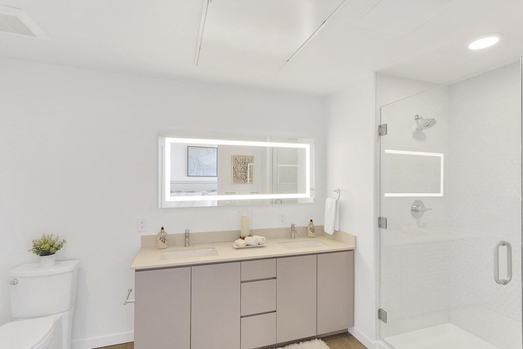 a bathroom with white walls and a white bathtub with a glass shower door