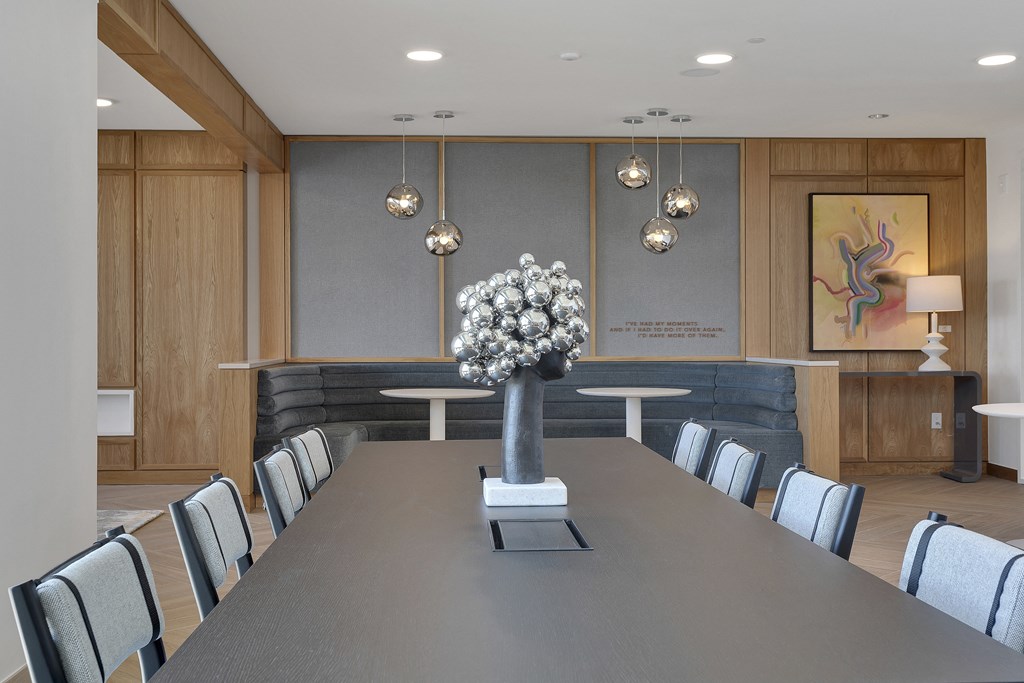 a rendering of a meeting room with a long table with a vase of flowers on it