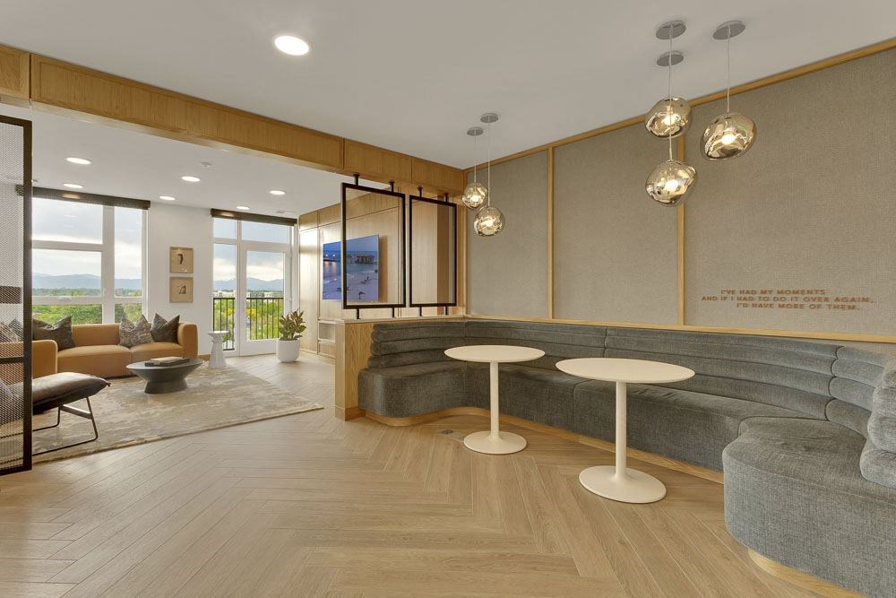 a lobby with a gray couch and two tables