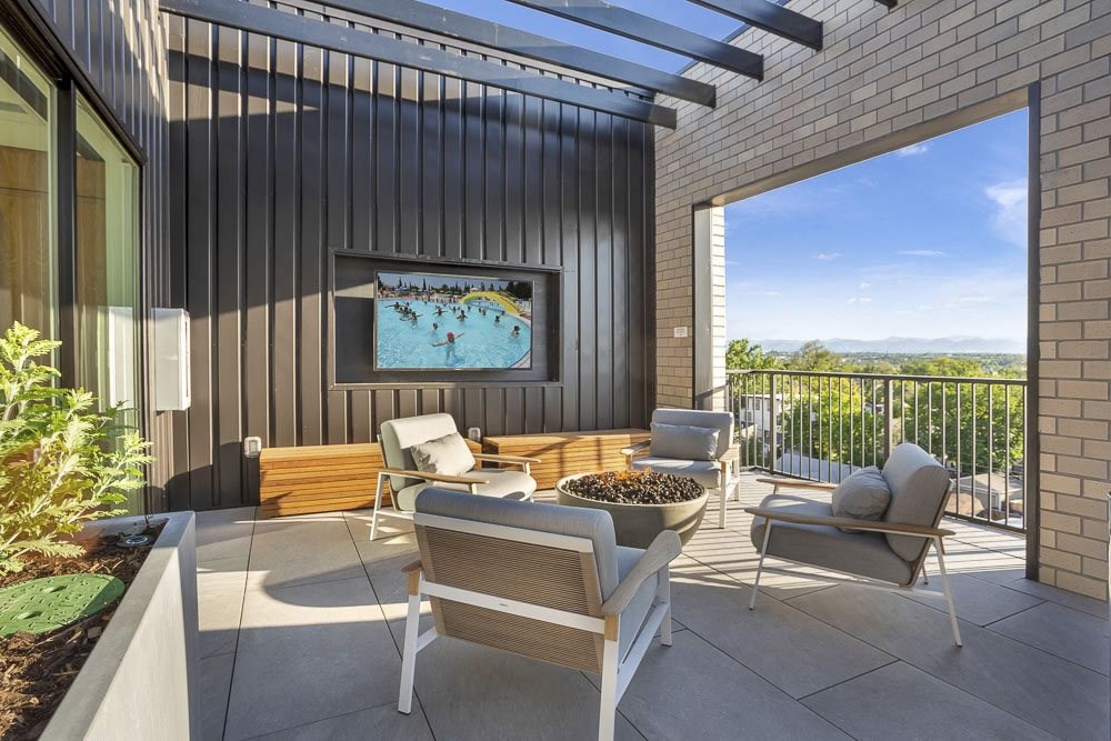 a patio with chairs and a fire pit