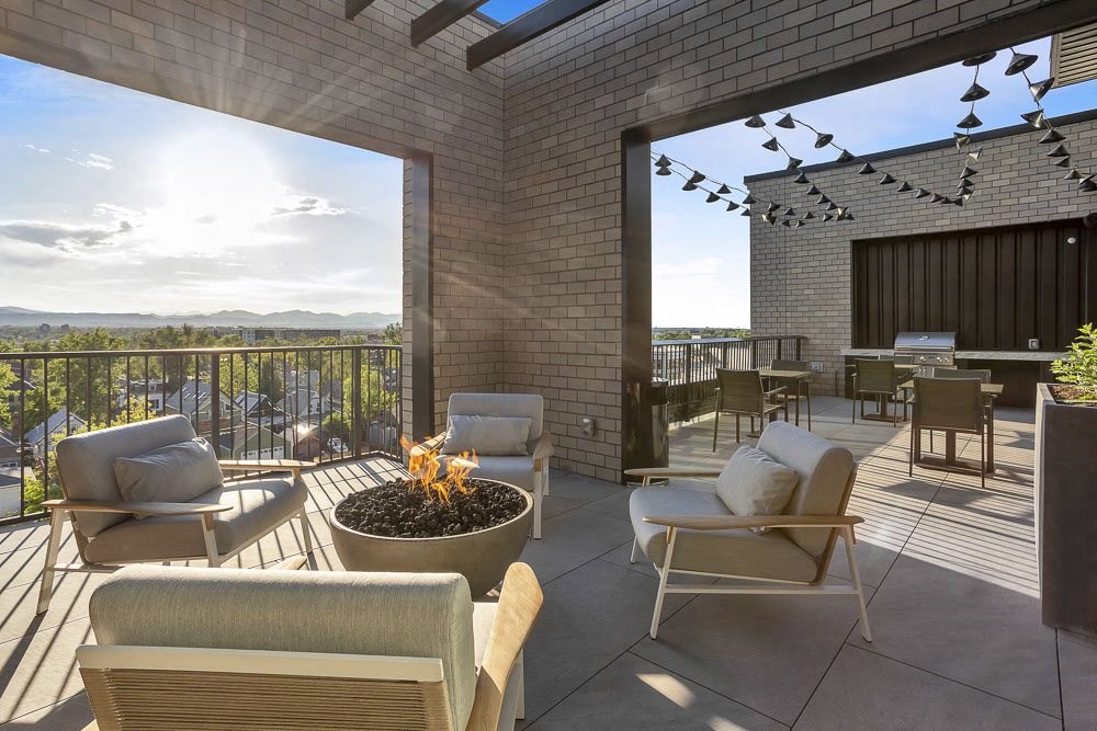 a patio with chairs and a fire pit