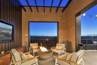 a patio with a fire pit and a view of the city