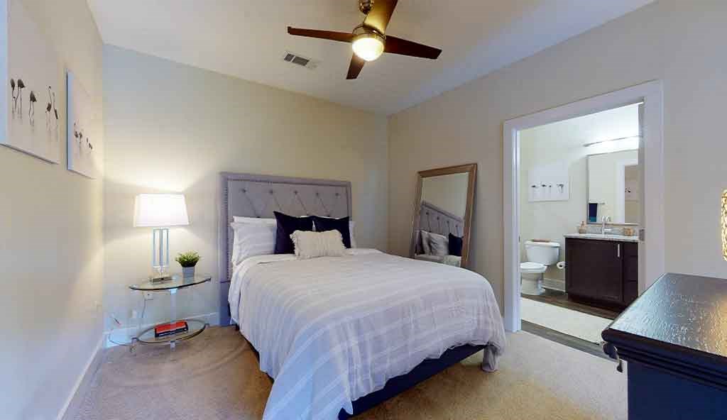 a bedroom with a bed and a ceiling fan