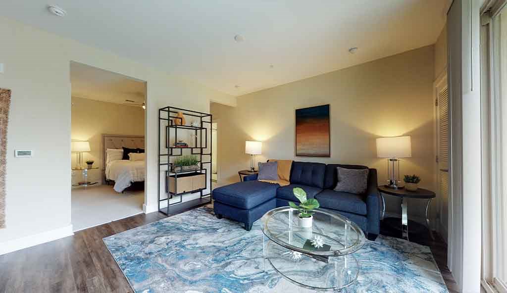 a living room with a blue couch and a glass table