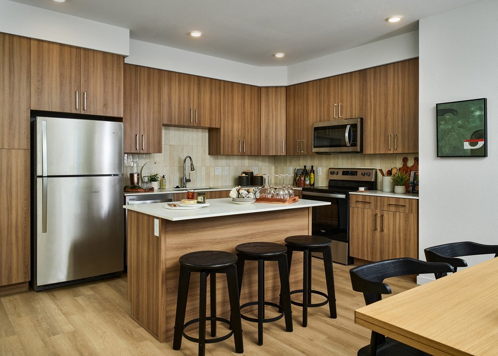 a kitchen with a center island with three stools