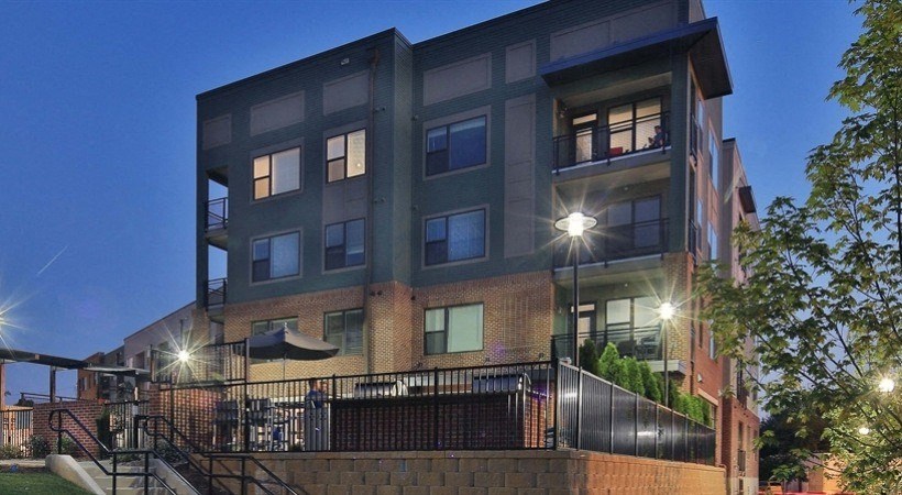 an apartment building at night with street lights