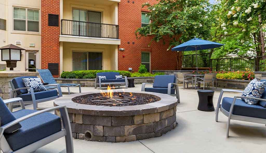 an outdoor patio with a fire pit and chairs