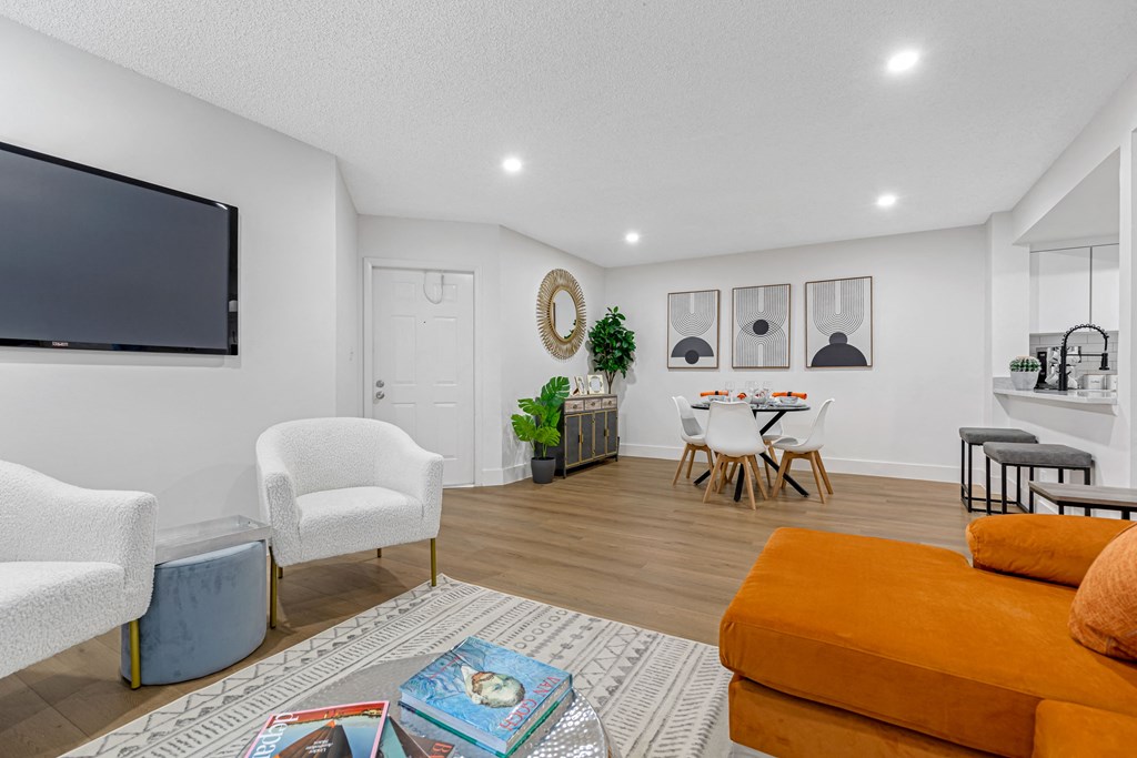 a living room with white walls and a flat screen tv on the wall