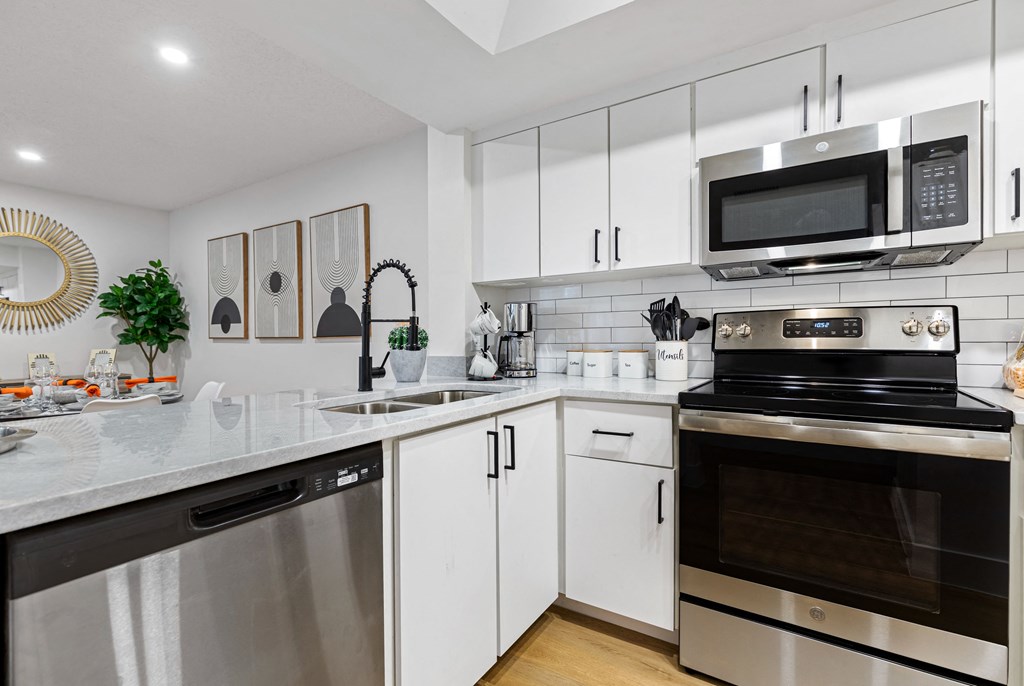 a kitchen with white cabinets and stainless steel appliances