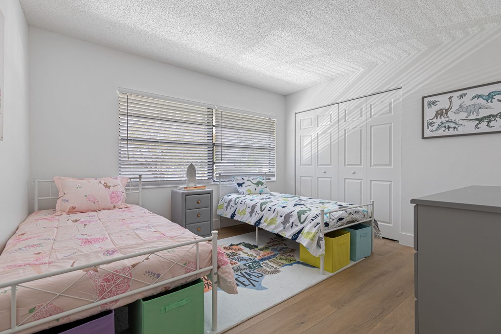 a bedroom with two beds and a dresser