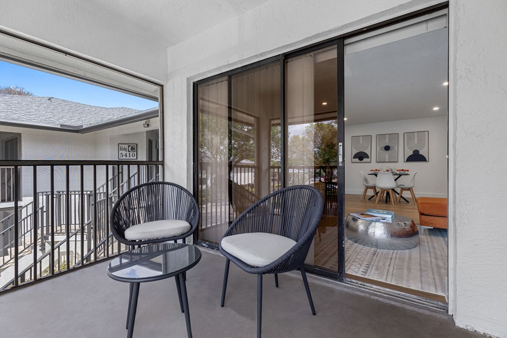 a balcony with two chairs and a fire pit