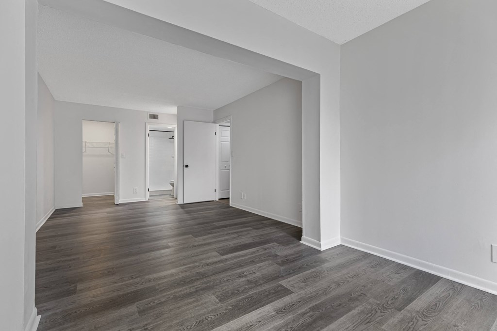 a bedroom with hardwood flooring and white walls