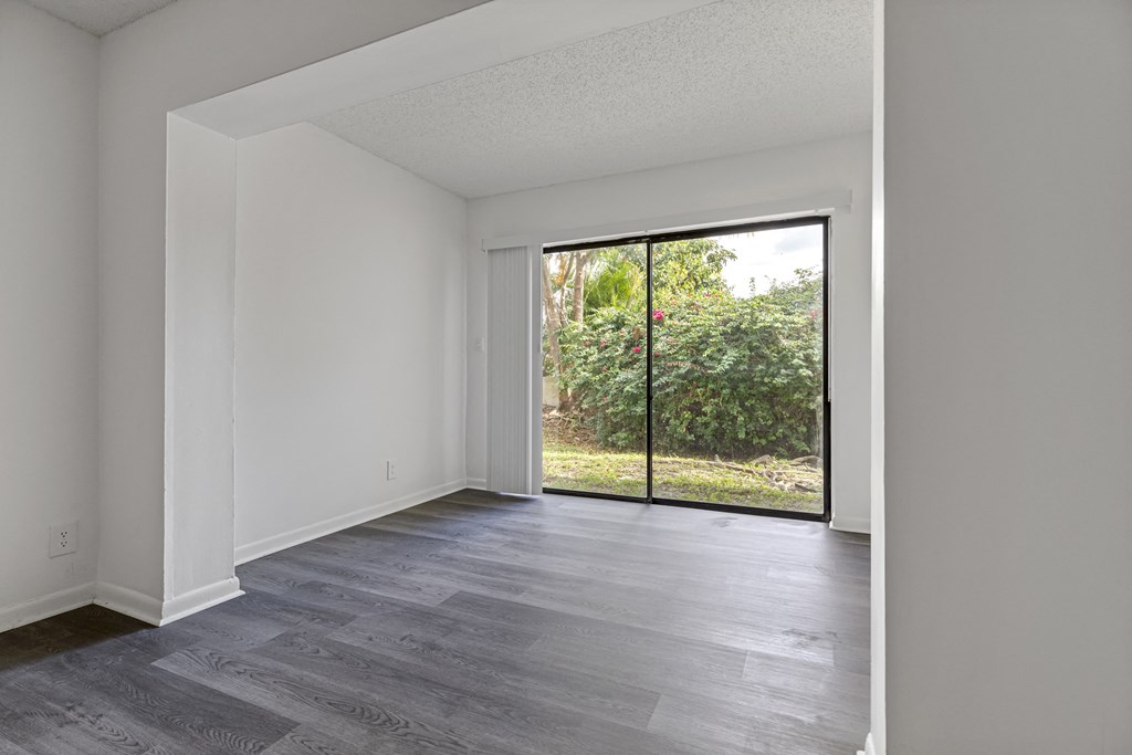 a bedroom with hardwood floors and white walls