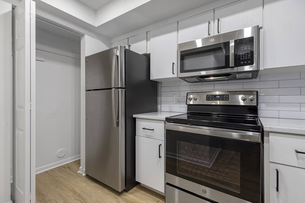 a kitchen with white cabinetry and stainless steel appliances