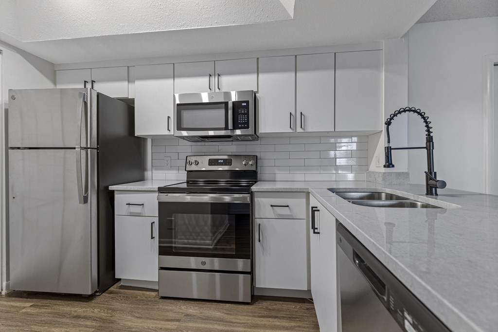 a kitchen with white cabinets and stainless steel appliances