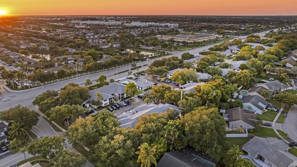 an aerial view of a neighborhood with a sunset in the background