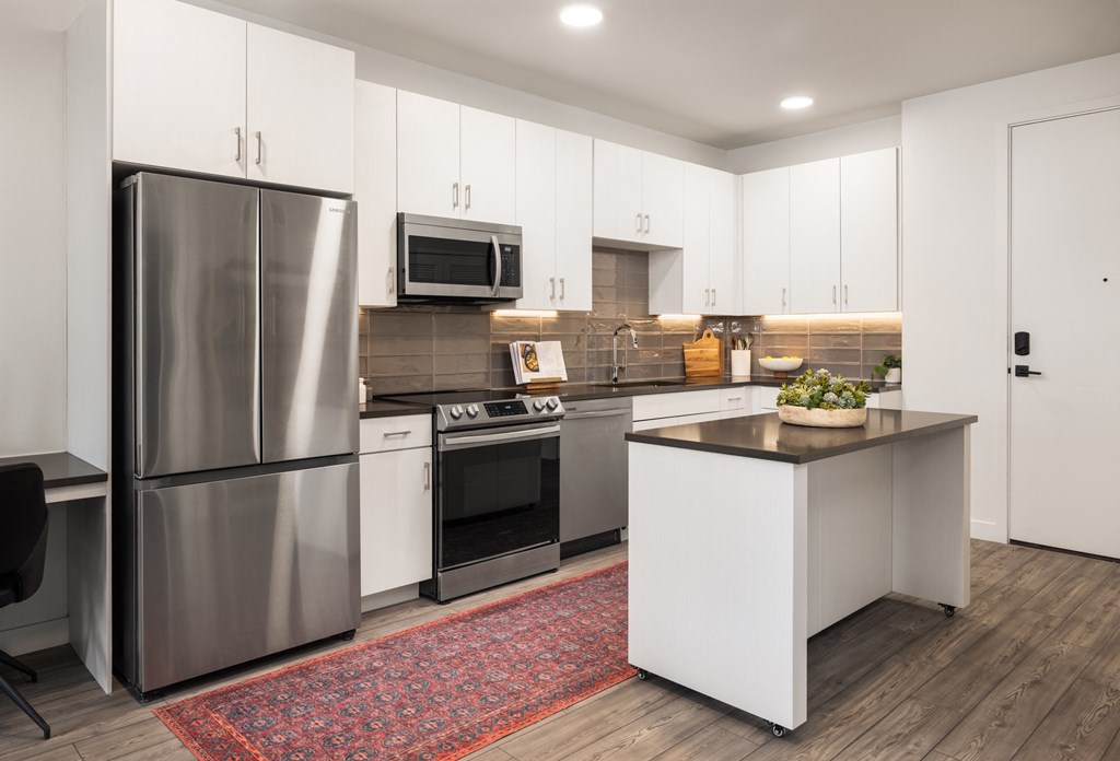 a kitchen with stainless steel appliances and white cabinets