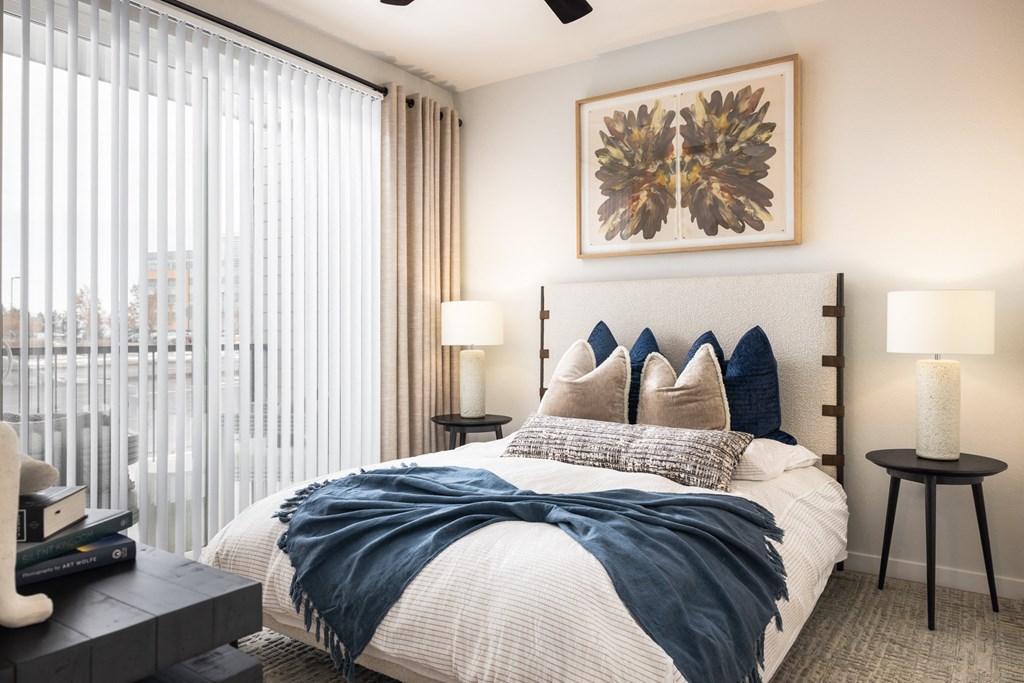 A bedroom with a large bed and a ceiling fan.