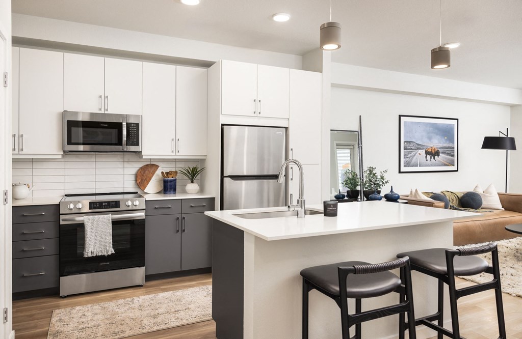 A modern kitchen with a large island and bar stools.