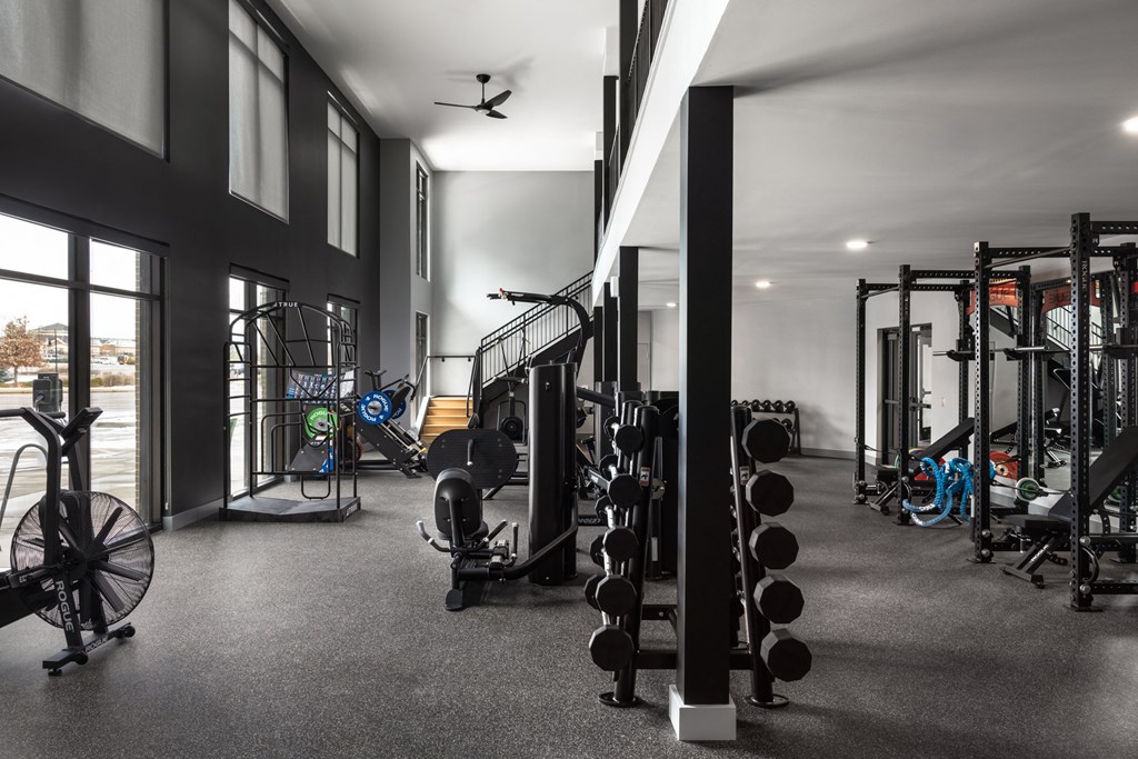 A gym with a variety of equipment including weights and cardio machines.