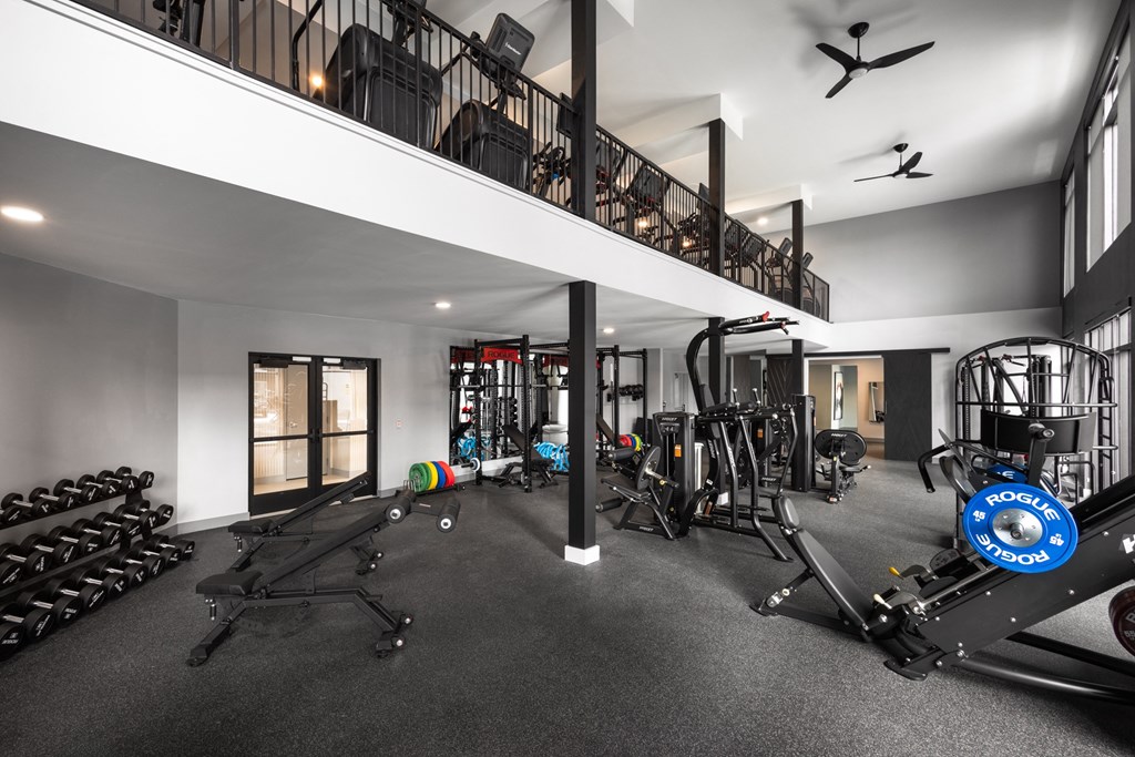 A spacious gym with a variety of equipment including treadmills, weights, and exercise machines.