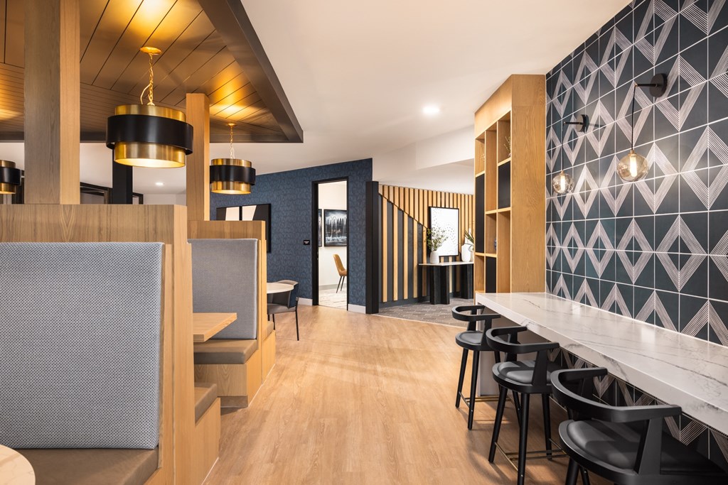 A modern restaurant with wooden floors and bar stools.