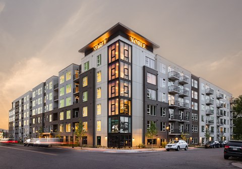a large apartment building on a city street at dusk