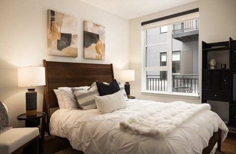 A bedroom with a large bed and a chair.