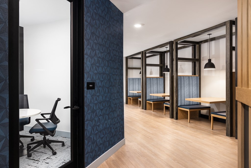 A room with a blue patterned wall and a black chair.