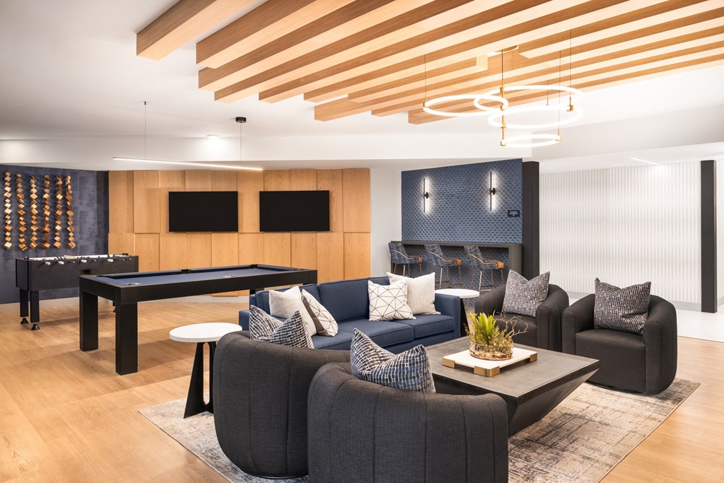 A modern living room with a pool table and a fireplace.