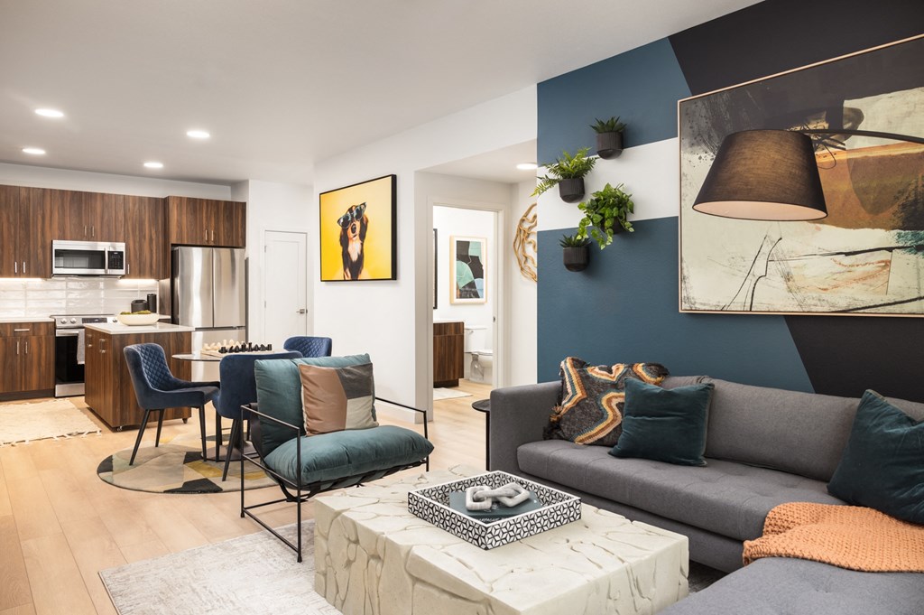 a living room with a blue accent wall and a gray couch