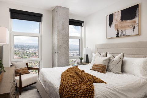 A bedroom with a large bed and a view of the city.