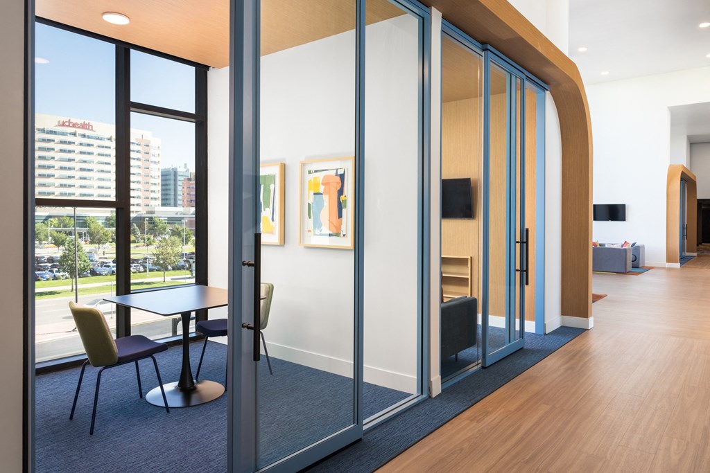 a conference room with glass walls and a table and chairs