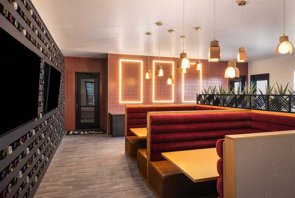 A modern bar with a red booth and a wall of bottles.