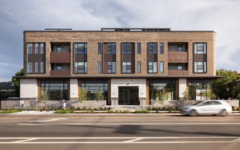 A modern building with a mix of brick and glass facade.